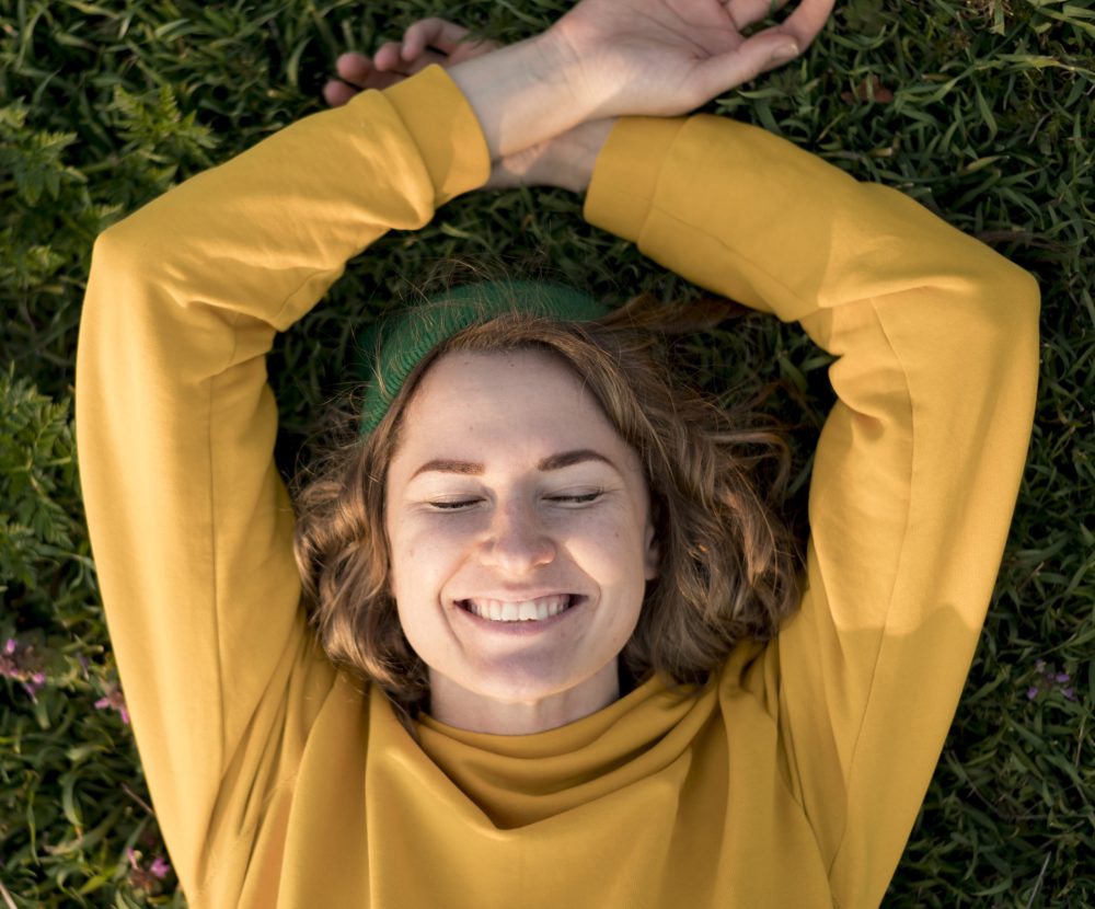 top-view-smiley-girl-staying-grass